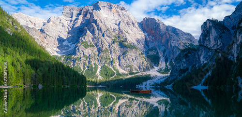 Braies Lake in Dolomites mountains forest on the background. The lake is surrounded by forest which are famous for scenic hiking trails. Mountain landscape, lake and mountain range.