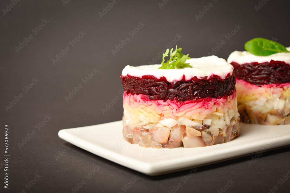Close up to Traditional holiday layered fish salad Herring under fur coat served in culinary rings. Copy space image with text space. Russian salad with beetroot, potato, onion, fish and mayonnaise Close up to Traditional holiday layered fish salad Herring under fur coat served in culinary rings. Copy space image with text space. Russian salad with beetroot, potato, onion, fish and mayonnaise