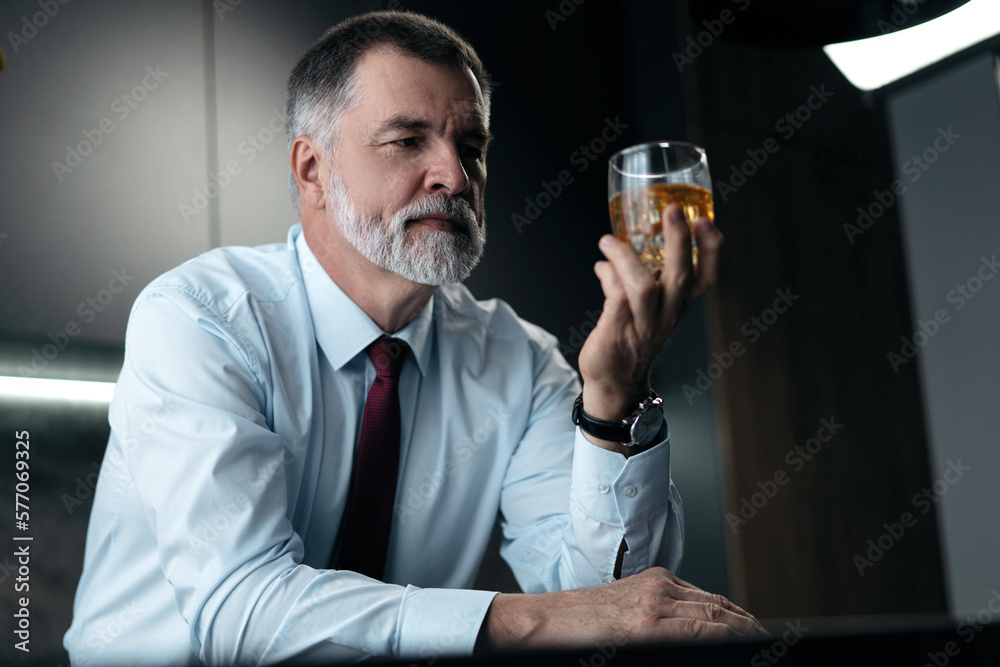 Confident rich mature wealthy businessman chilling relaxing drinking enjoying whiskey in the kitchen after work. Confident rich mature wealthy businessman chilling relaxing drinking enjoying whiskey in the kitchen after work.