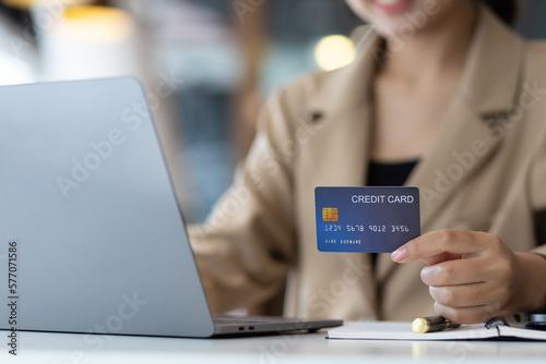 Happy businesswoman using credit card and laptop.