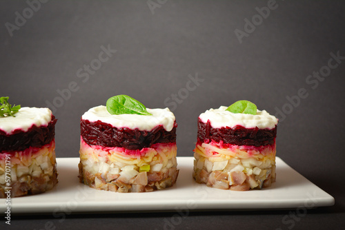 Wallpaper Mural Side view of Traditional holiday layered fish salad Herring under fur coat served in culinary rings. Three serving sizes of Eastern Europe salad with beetroot, potato, onion, fish and mayonnaise Torontodigital.ca