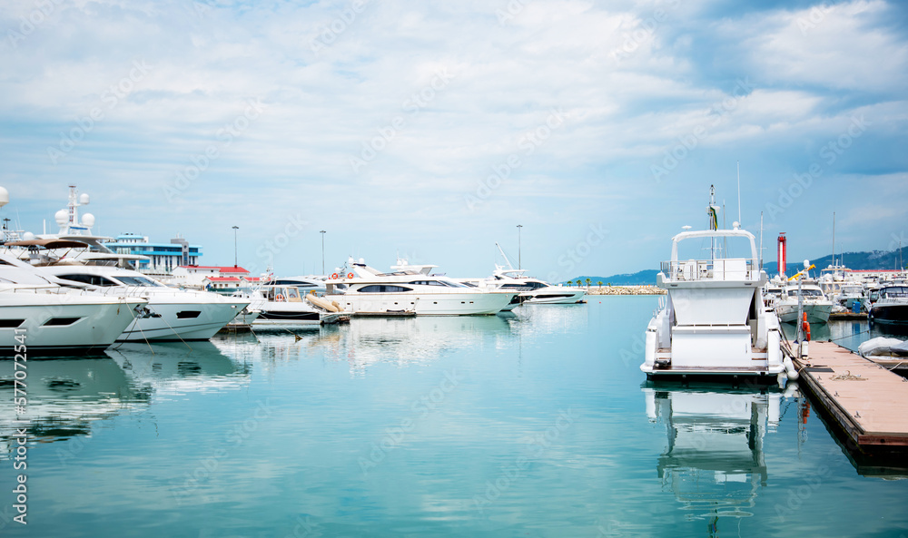 Fototapeta premium Yacht parking in harbor, harbor yacht club. Beautiful Yachts in blue sky background. Luxury super yacht marina and sailing boats.