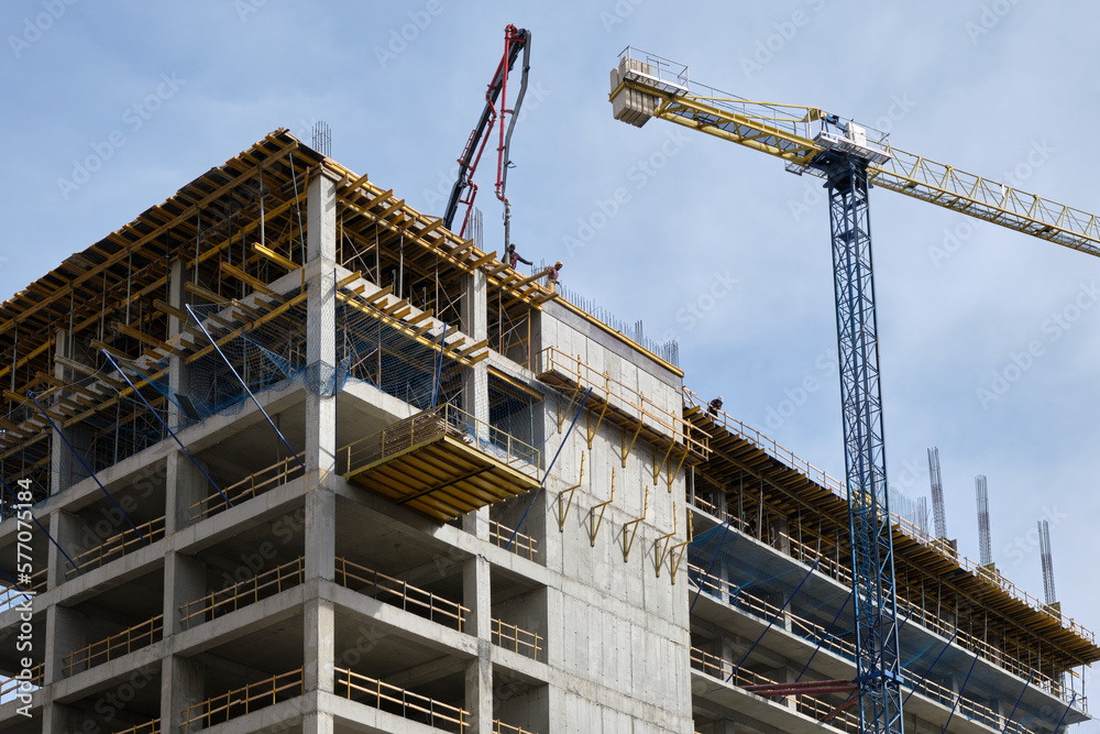 Workers pour concrete at the construction site of a new residential building Workers pour concrete at the construction site of a new residential building