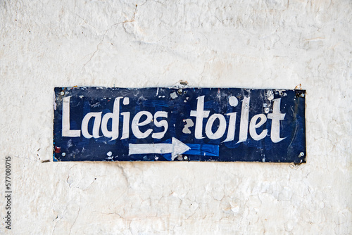 Handpainted sign ''ladies toilet'' in white and blue.