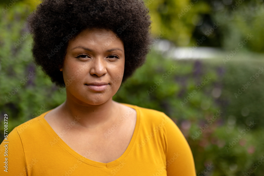 Portrait of african american mid adult woman with afro hairstyle standing in garden Portrait of african american mid adult woman with afro hairstyle standing in garden