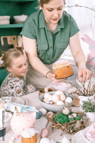 happy easter holiday time in spring season. family kid girls children sisters and young woman holds baked pastry cake or traditional bread in her hands. traditional handmade food. festive home decor