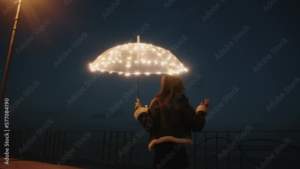 Happy girl with transparent umbrella in the night 