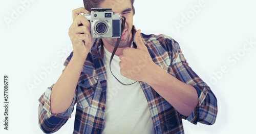 Caucasian man clicking picture with digital camera against copy space on white background