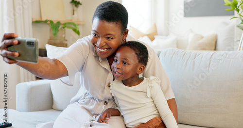 Smartphone, selfie and mother with child on living room sofa for social media post, parents blog update or family home celebration. Black family smile in cellphone portrait photography for online app