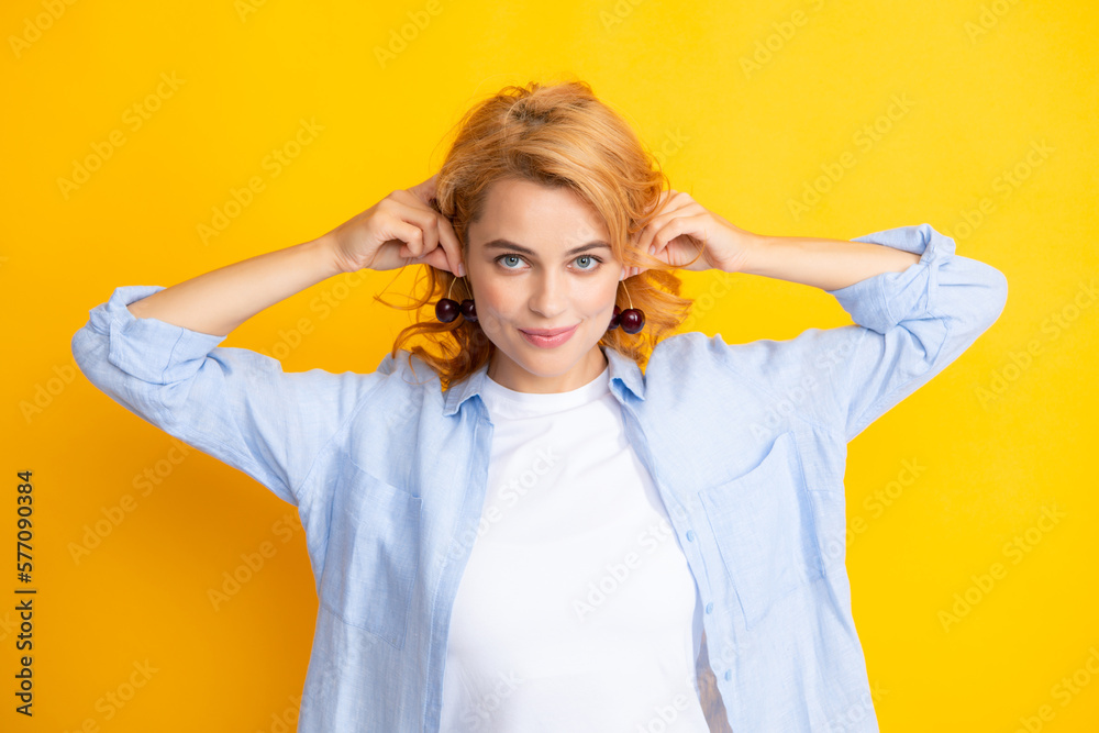 Womans enjoying a fresh sweet cherry. Female eating cherries on yellow background.