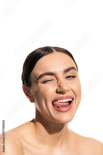 close up of happy young woman with flawless natural makeup sticking out tongue isolated on white.