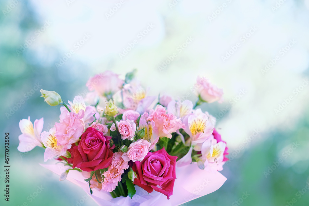 Gentle beautiful floral bouquet in pink-red colors close up on abstract blurred natural background. romantic floral festive image. template for design