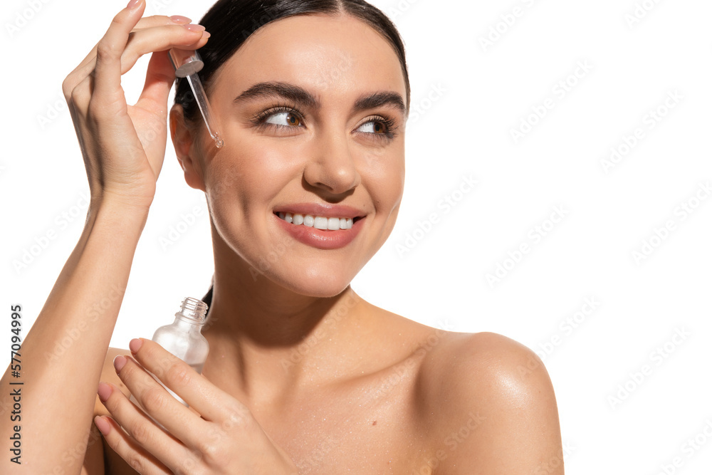 positive and brunette woman holding pipette with serum isolated on white.