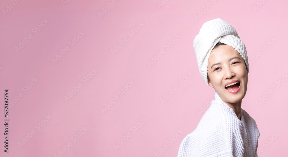 Beautiful young asian woman happy with clean face skin in towel and bathrobe, spa suit on pink background. Skincare, treatment, wellness therapy, facial care, beauty female health, cosmetology concept Beautiful young asian woman happy with clean face skin in towel and bathrobe, spa suit on pink background. Skincare, treatment, wellness therapy, facial care, beauty female health, cosmetology concept