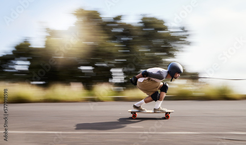 Skateboard, motion blur and mountain with man in road for speed, freedom and summer break. Sports, adventure and wellness with guy skating fast in street for training, gen z and balance in nature