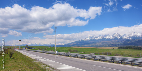 Obraz na płótnie highway through the slovakian countryside, revealing a scenic view of the beautiful tatra mountains. the road leads through vast farmland, providing a beautiful backdrop for the journey w salonie
