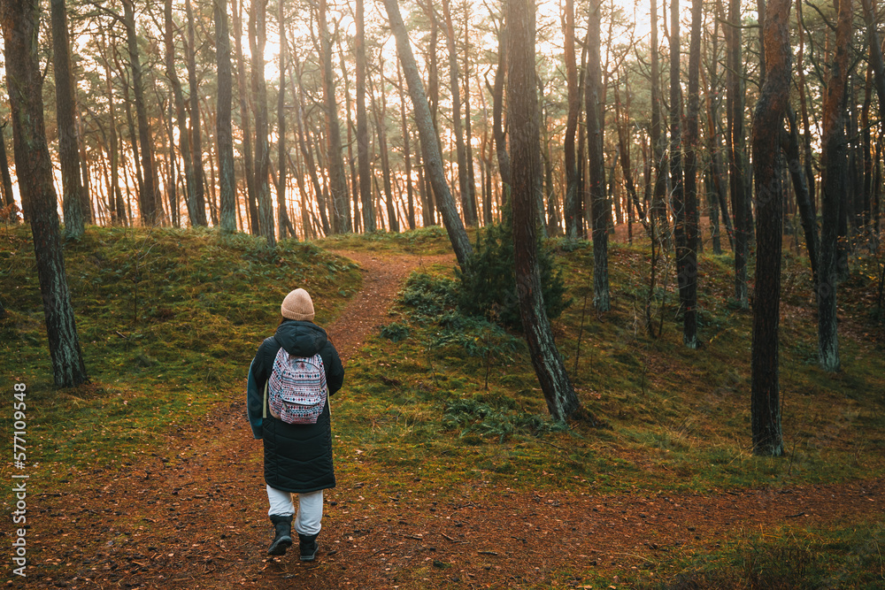 Woman with a backpack walking in the park. Concept of traveling alone and outdoors discovering. Person in the forest. Woman with a backpack walking in the park. Concept of traveling alone and outdoors discovering. Person in the forest.