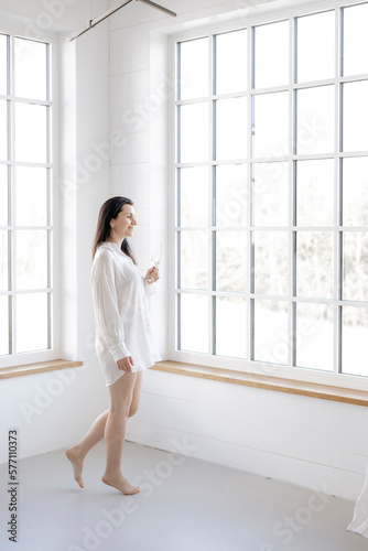 Attraktive Frau im weißen Hemd vor Fensterfront