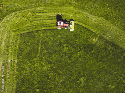 Top down view farmer mowing a green grass field 