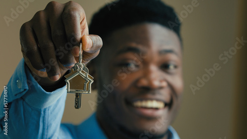 Happy homeowner african american ethnic man 30s businessman real estate agent office worker owner showing keys from new home at camera house buying loan housing mortgage sale apartment business offer