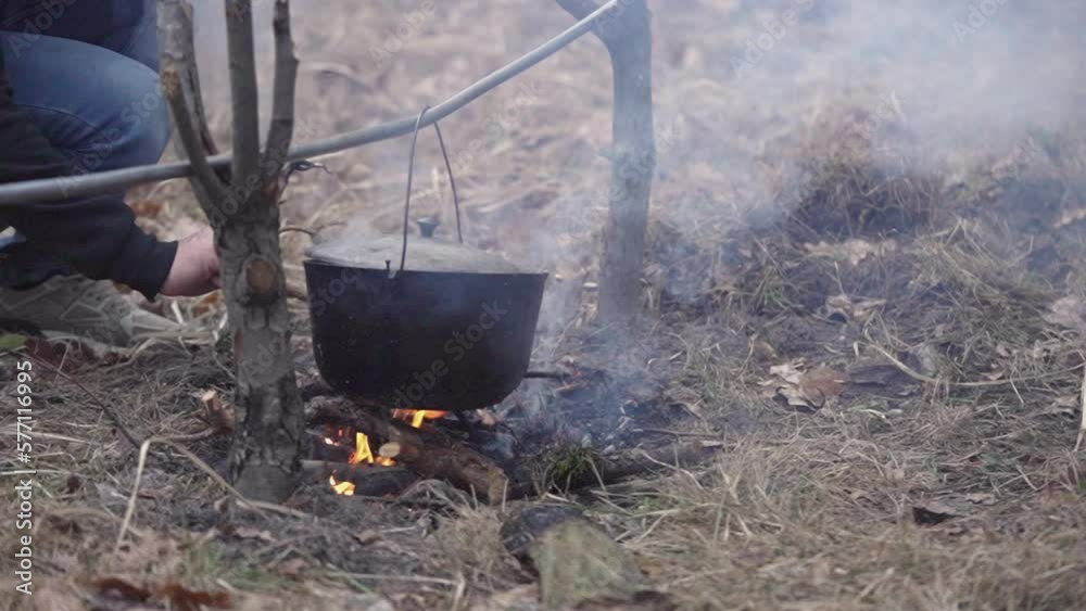 The guy puts firewood on the campfire The guy puts firewood on the campfire