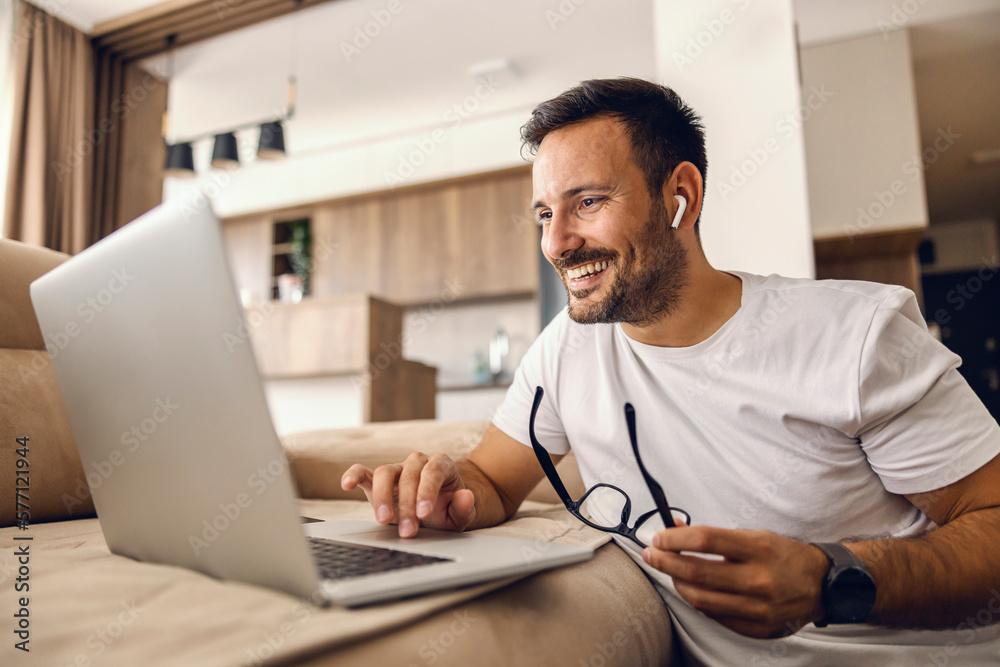 A happy man sits at home and spending time on social media on the laptop. A happy man sits at home and spending time on social media on the laptop.