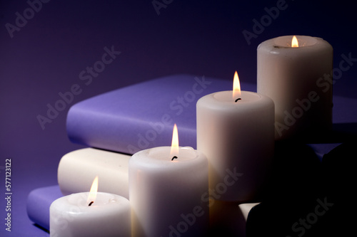 candles and books with purple background