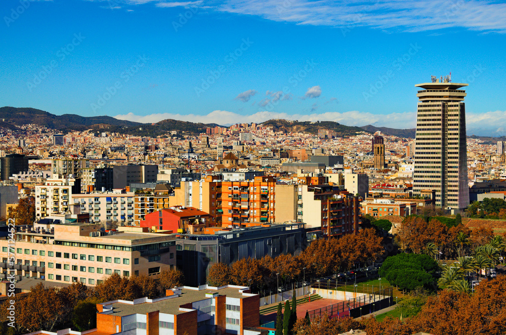 Aerial landscape view of colorful residential buildings in downtown of Barcelona. Panoramic cityscape of Barcelona during sunny day. Mountains in the background. Travel and tourism concept