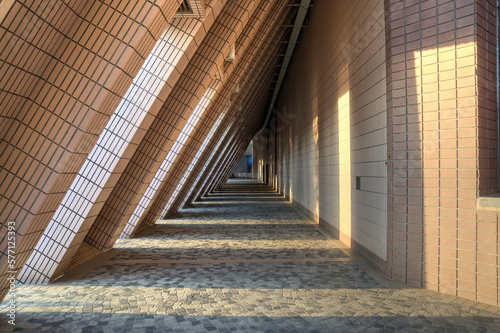 The sun casting shadows on a sheltered Tsim Sha Tsui public path in Hong Kong.