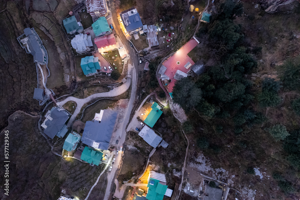 aerial drone shot top down view of traffic in narrow winding hill roads with lights shining on cars and buildings shot in manali shimla himachal