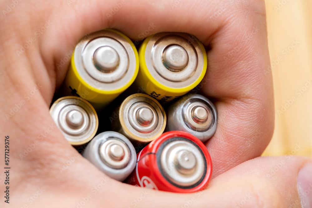 Man holding a bunch of rechargeable batteries, power and energy storage
