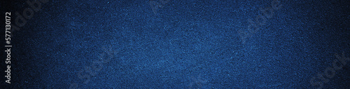 Black navy blue texture background with space for design. Dark rough concrete wall surface. Close-up. Web banner. Wide. Panoramic.