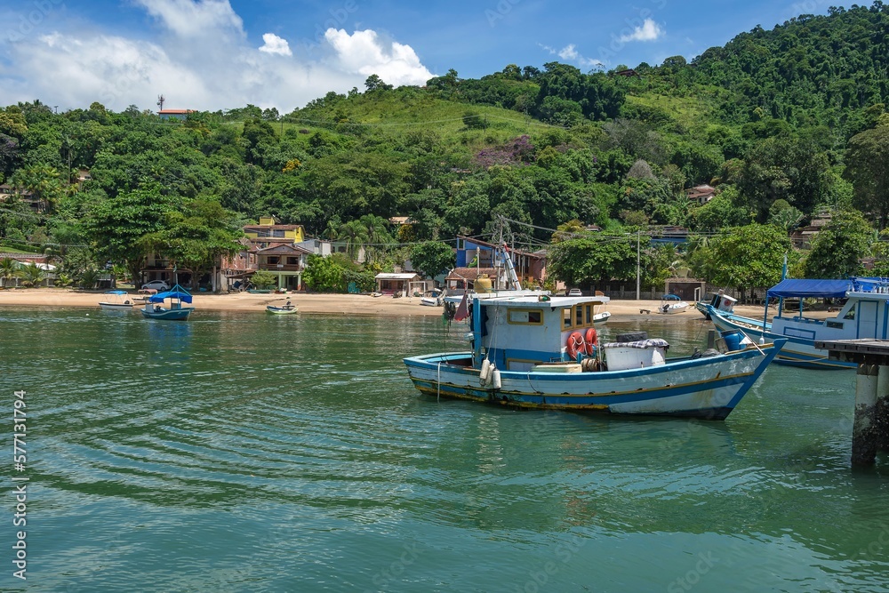Paraty, Brazil. Big beach. Fishing boats moored in the bay. Beach with calm waters and a fishing village with a warehouse. Paraty, Brazil. Big beach. Fishing boats moored in the bay. Beach with calm waters and a fishing village with a warehouse.