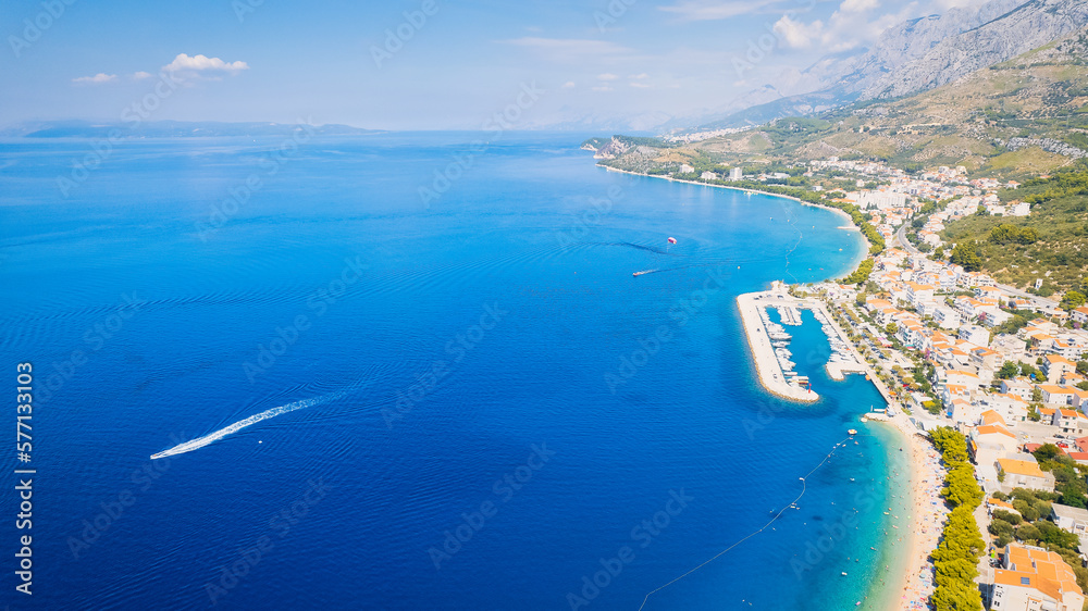 Croatia's harbor is a sight to behold from above. This breathtaking aerial view captures the colorful landscape filled with sailboats, motorboats, and luxurious yachts resting in a clear blue bay. Add