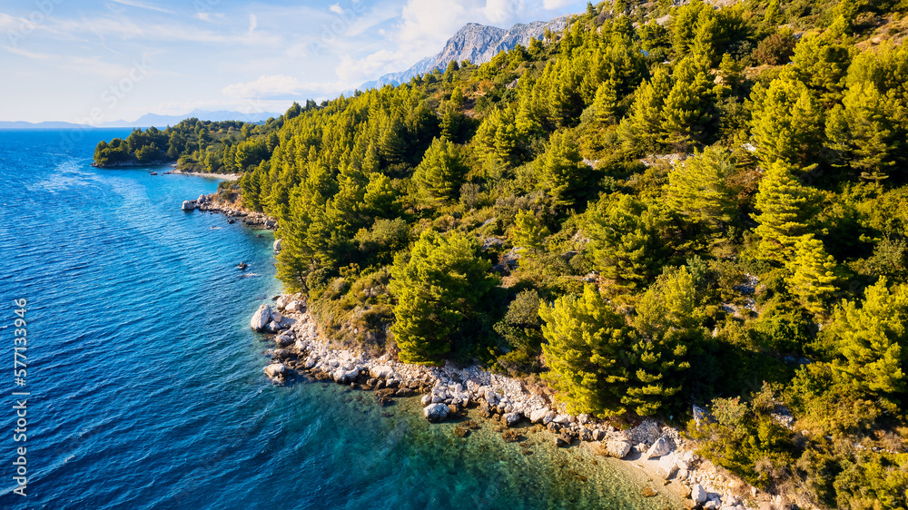 Fototapeta premium The stunning beauty of Croatia's rocks and forests is captured in this breathtaking aerial view. Take in the turquoise waters and beach from above, and add this travel image to your collection of unfo