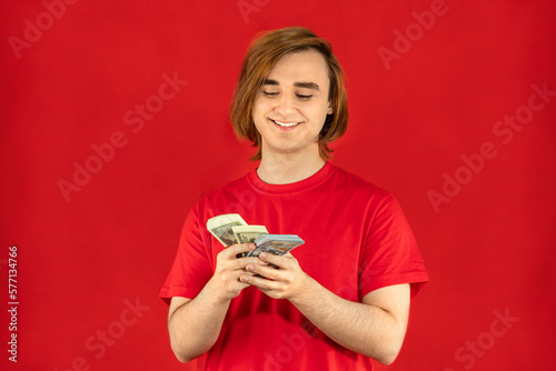Emotional young man with cash. Guy with currency banknotes. The concept of a successful money story  start-up  student loan  part-time job  winning