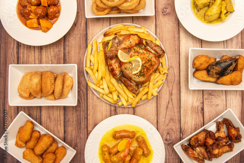 Set of typical Spanish food tapas dishes with known recipes, Sunday roast chicken, croquettes, empanadillas, tigres mussels, chistorra with potatoes