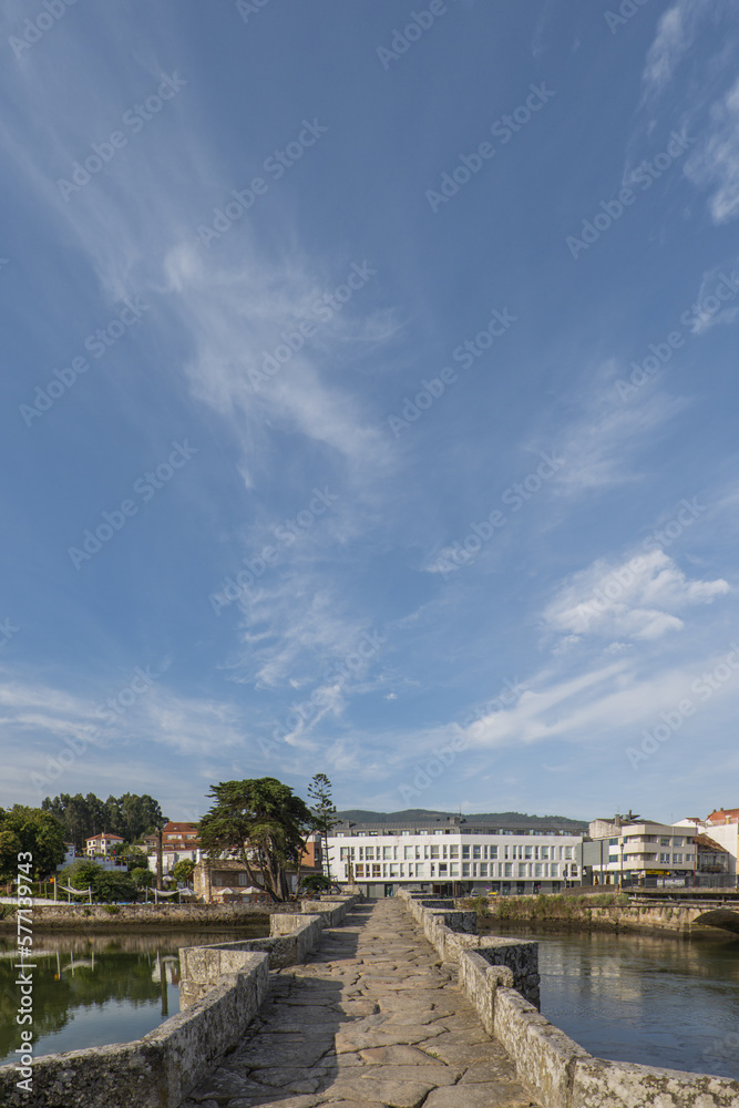 Views of the Romanesque Bridge that crosses the river Miñor in La Ramallosa that connects Baiona with Nigran in Galicia, Spain a beautiful summer morning
