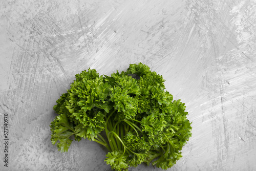 Fresh green parsley on gray background top view.