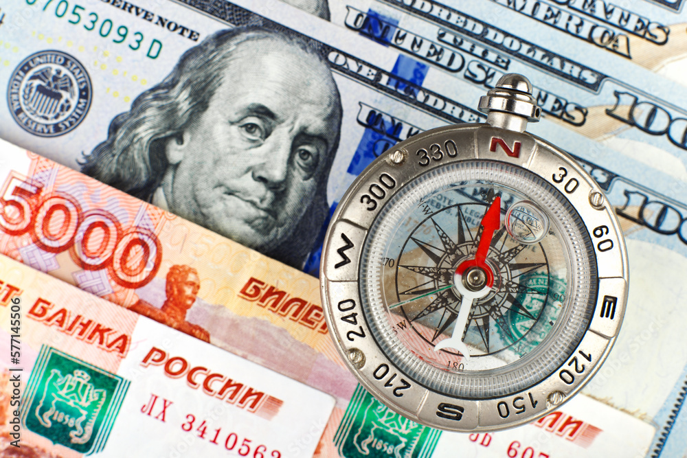 Compass with arrow pointing up on the background of Russian and American banknotes Compass with arrow pointing up on the background of Russian and American banknotes