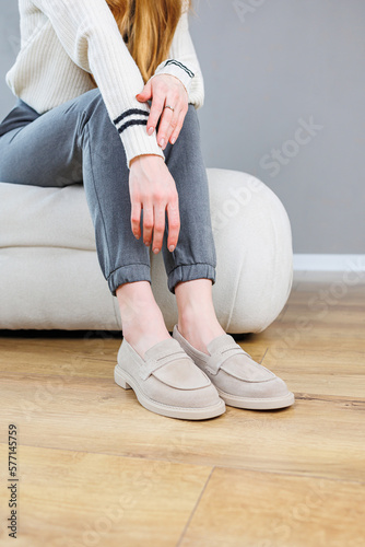 Female legs close-up in gray shoes without heels. Women's comfortable summer casual shoes. Gray women's spring shoes