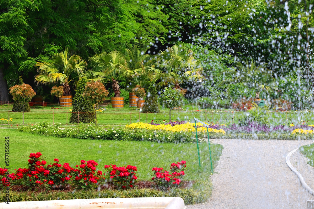 Colorful flowers, lush trees and fountain in botanical garden, in Zagreb, Croatia.