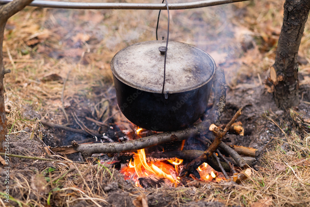Close-up of a cauldron hung over a campfire