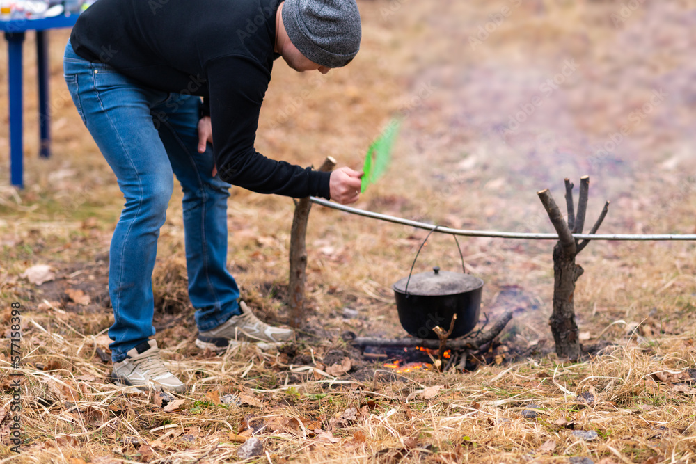 The guy in the foreground supports the campfire
