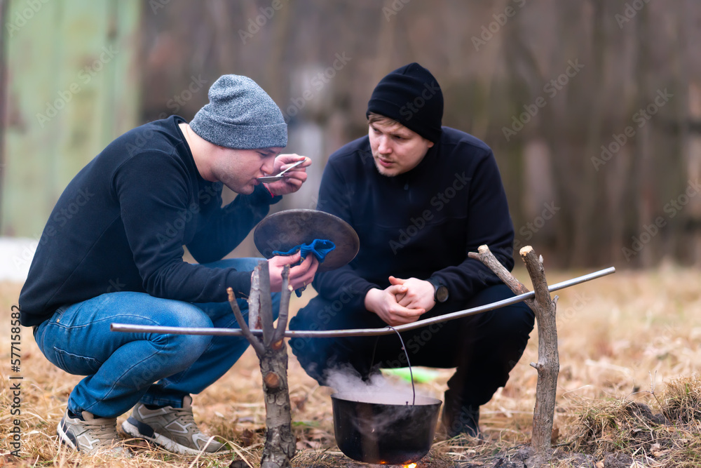 Young man tasting soup from a spoon