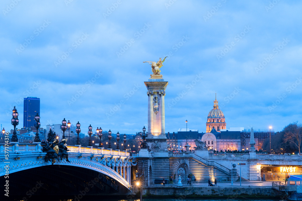 Paris landmark - famouse Alexandre III Bridge over Seine under blue sky at night, Paris, France