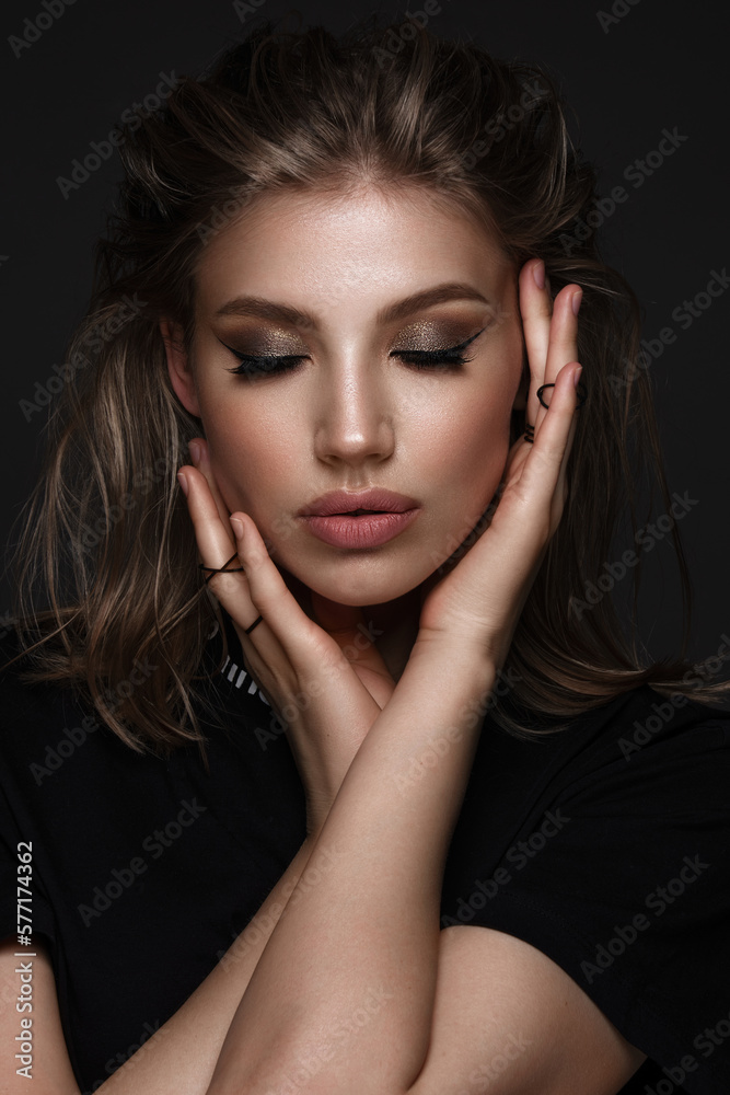 Portrait of a beautiful woman in a black dress with creative makeup in ...