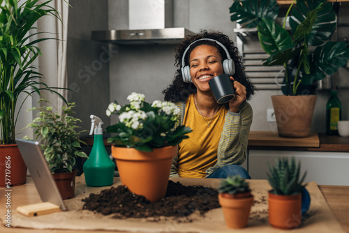 Happy florist listens to music and enjoys working with plants