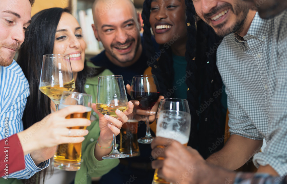 Group of diverse friends sharing beers and good times at home . A celebration of diversity, youth and the joy of socializing with other people.