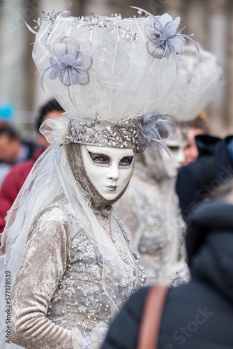 Beautiful candid white carnival mask. Mask that looks at me with blue eyes, covered in pearls and flowers. Venetian masks with sensuality and extravagance.